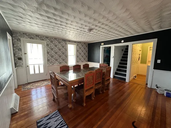 a dining room with furniture window and wooden floor