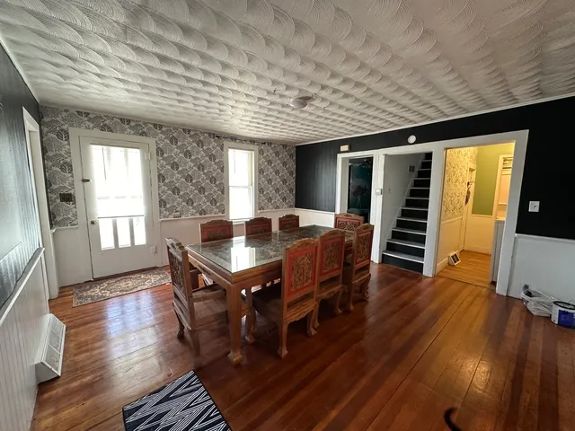 a dining room with furniture window and wooden floor