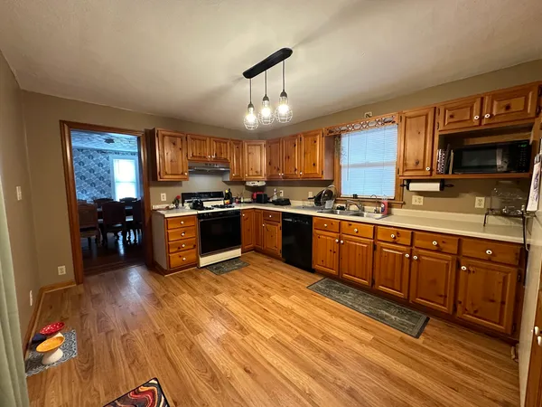 a large kitchen with stainless steel appliances granite countertop a stove sink and cabinets