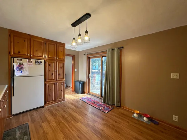 a view of a room with wooden floor and a refrigerator