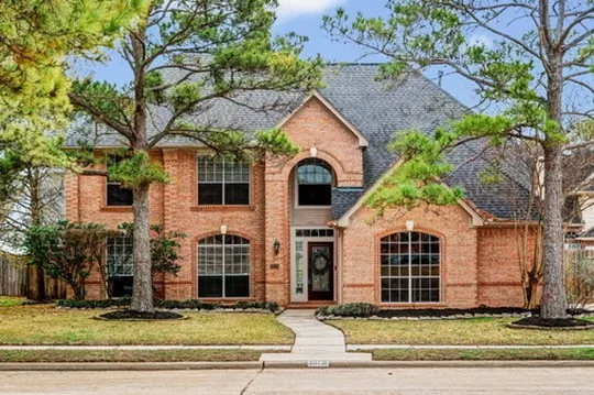 a view of a white house with large windows and a large tree