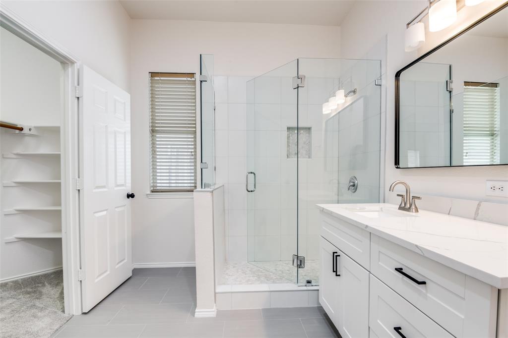405 Hackberry Drive Fate, TX 75087 - Photo 16 of 24 a bathroom with a double vanity sink mirror and shower
