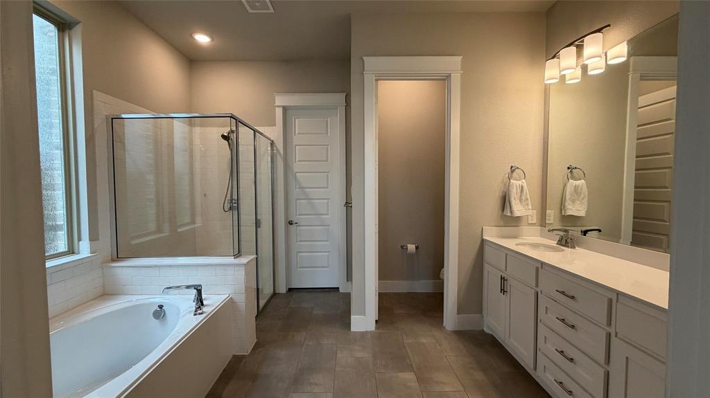 912 Fallbrook Avenue Denton, TX 76210 - Photo 10 of 26 a bathroom with a tub a sink and mirrors