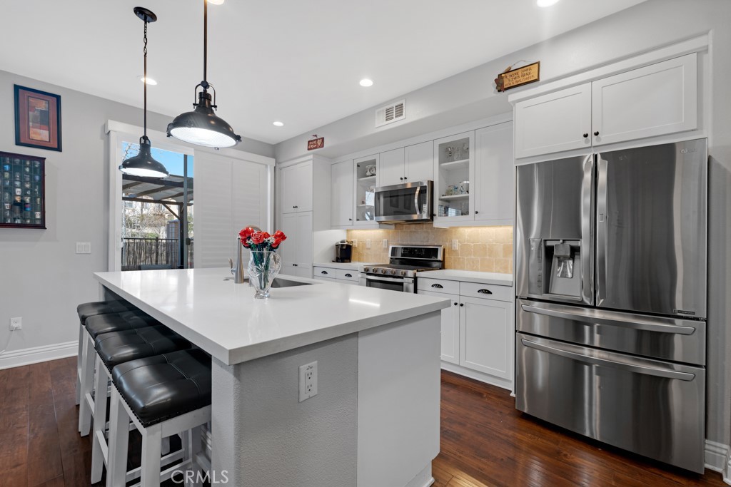 22104 Barrington Way Saugus, CA 91350 - Photo 6 of 31 a kitchen with stainless steel appliances a sink a stove a refrigerator and cabinets