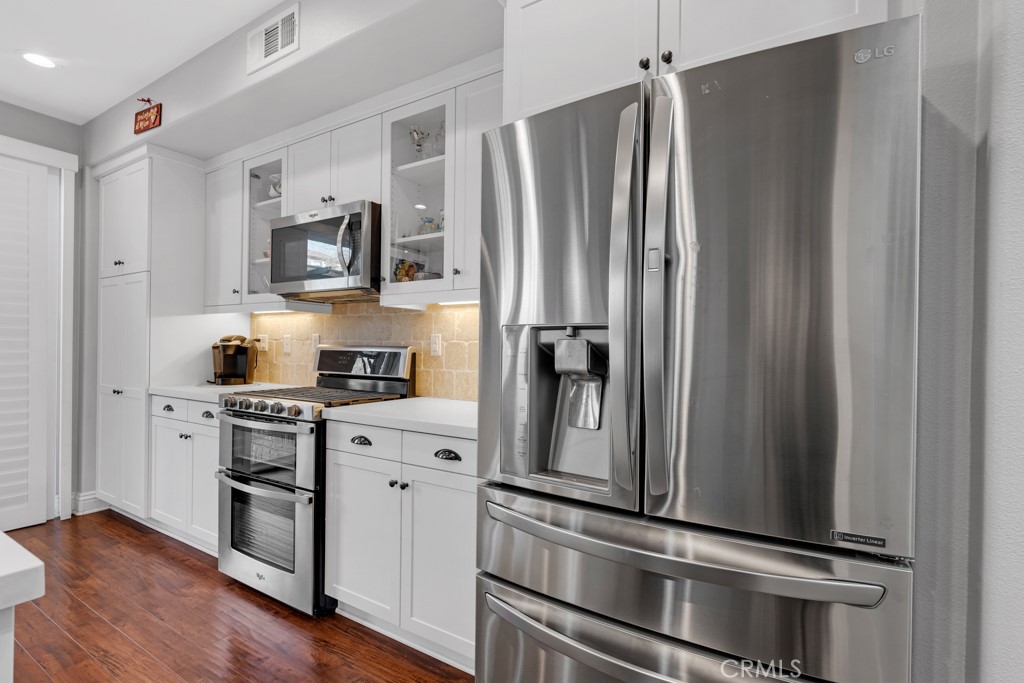 22104 Barrington Way Saugus, CA 91350 - Photo 7 of 31 a kitchen with stainless steel appliances a refrigerator stove and sink