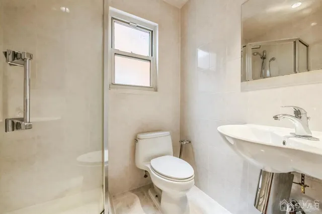 a bathroom with a toilet a sink and mirror