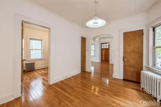 a view of a room with wooden floor staircase and a chandelier