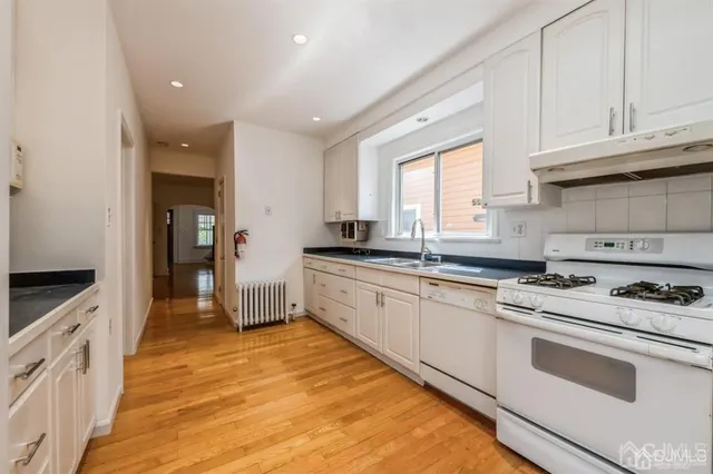 a kitchen with granite countertop cabinets stainless steel appliances a sink and a window