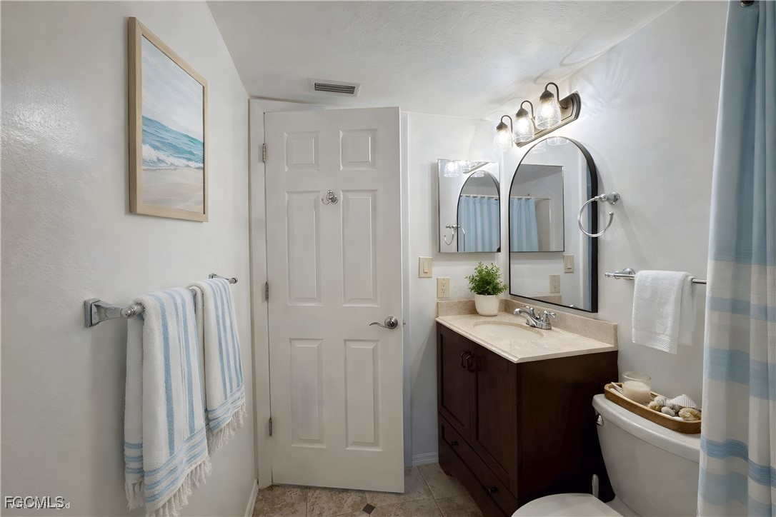 1211 Barrett Road, Unit 1106 North Fort Myers, FL 33903 - Photo 19 of 28 a bathroom with a sink mirror and toilet
