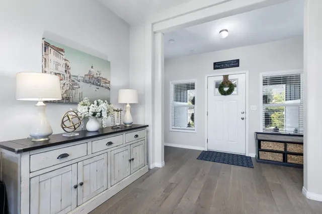 a hallway with white cabinets and wooden floor
