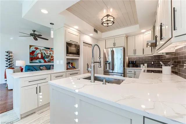 a kitchen with stainless steel appliances kitchen island granite countertop a sink and cabinets