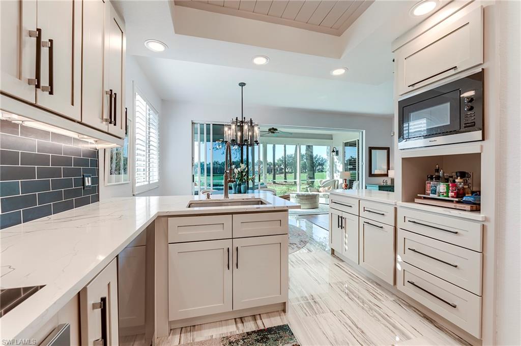 9241 Palmetto Ridge Drive, Unit 101 Estero, FL 34135 - Photo 12 of 28 a kitchen with counter top space cabinets and stainless steel appliances