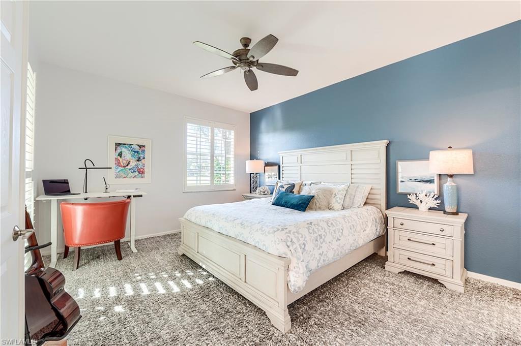 9241 Palmetto Ridge Drive, Unit 101 Estero, FL 34135 - Photo 16 of 28 a bedroom with a bed a lamp and a dresser