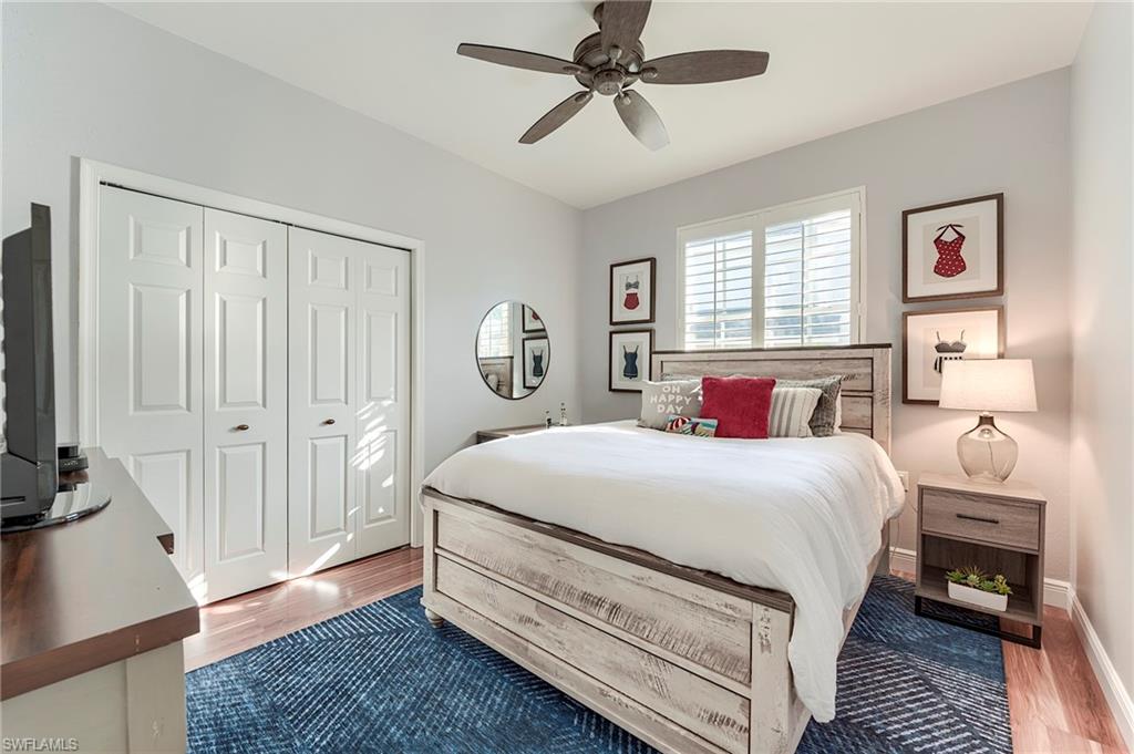 9241 Palmetto Ridge Drive, Unit 101 Estero, FL 34135 - Photo 20 of 28 a bedroom with a bed and a chandelier