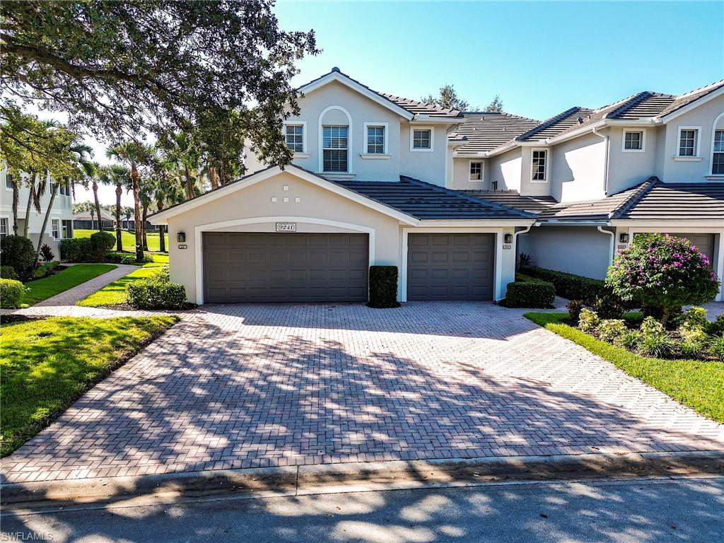 9241 Palmetto Ridge Drive, Unit 101 Estero, FL 34135 - Photo 25 of 28 a front view of a house with a garden and yard
