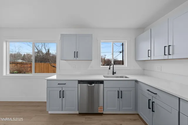 a kitchen with white cabinets and sink