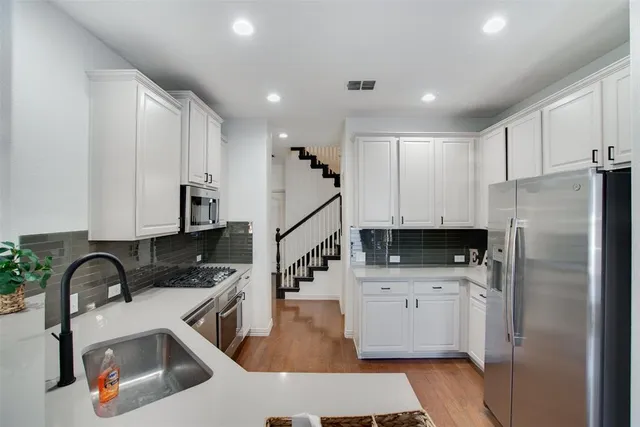 a kitchen with a sink a refrigerator and cabinets