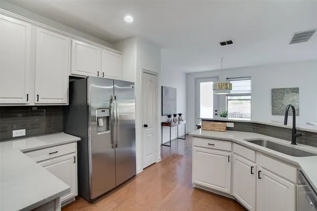 a large kitchen with stainless steel appliances granite countertop a lot of counter space and a sink