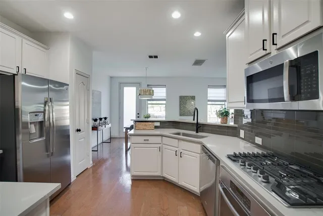a kitchen with stainless steel appliances kitchen island granite countertop a refrigerator and a sink