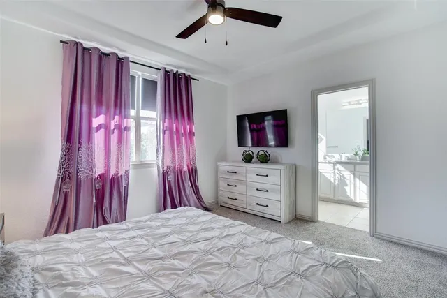 a bedroom with a bed and a flat screen tv in white walls