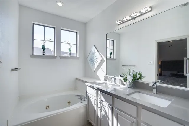 a bathroom with a tub a sink and mirror