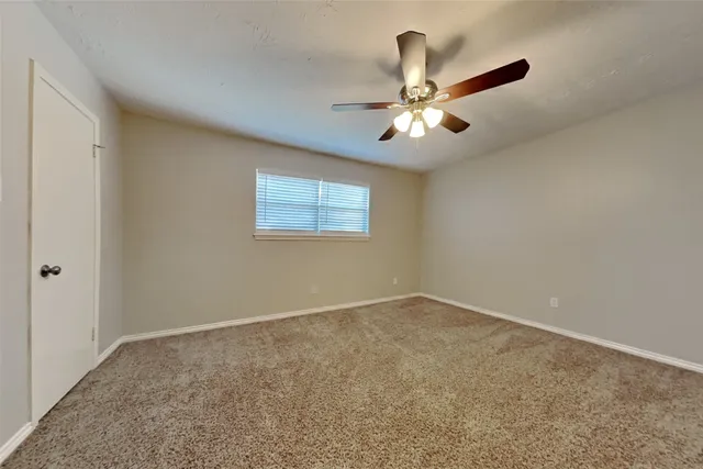 a view of an empty room with a ceiling fan