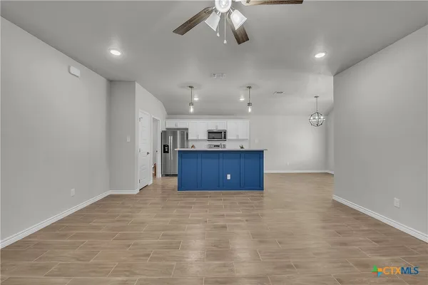 wooden floor in an empty room with a kitchen