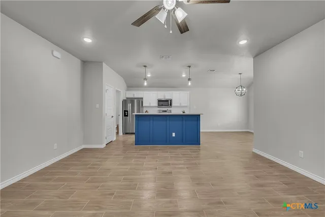 wooden floor in an empty room with a kitchen
