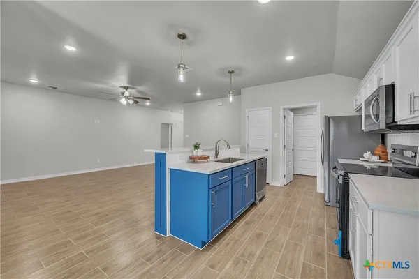 a large kitchen with stainless steel appliances granite countertop a large stove a sink dishwasher and a refrigerator with wooden floor