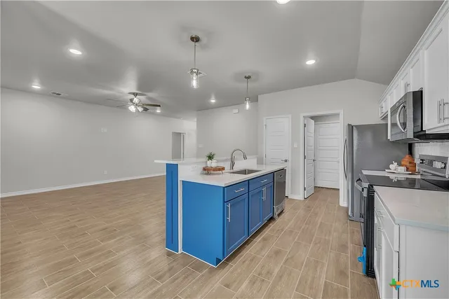 a large kitchen with stainless steel appliances granite countertop a large stove a sink dishwasher and a refrigerator with wooden floor