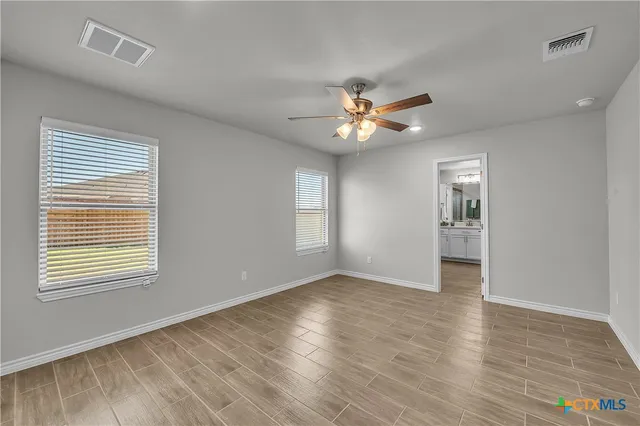 an empty room with wooden floor and window
