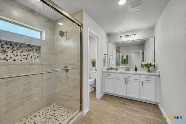 a bathroom with a double vanity sink toilet and shower