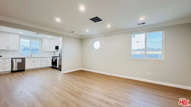 a view of kitchen with stove and cabinets