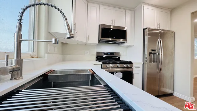 a kitchen with stainless steel appliances a stove a refrigerator and a sink