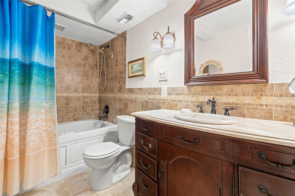 7514 Rocky Point Drive Hudson, FL 34667 - Photo 19 of 38 a bathroom with a sink a toilet a mirror and bathtub