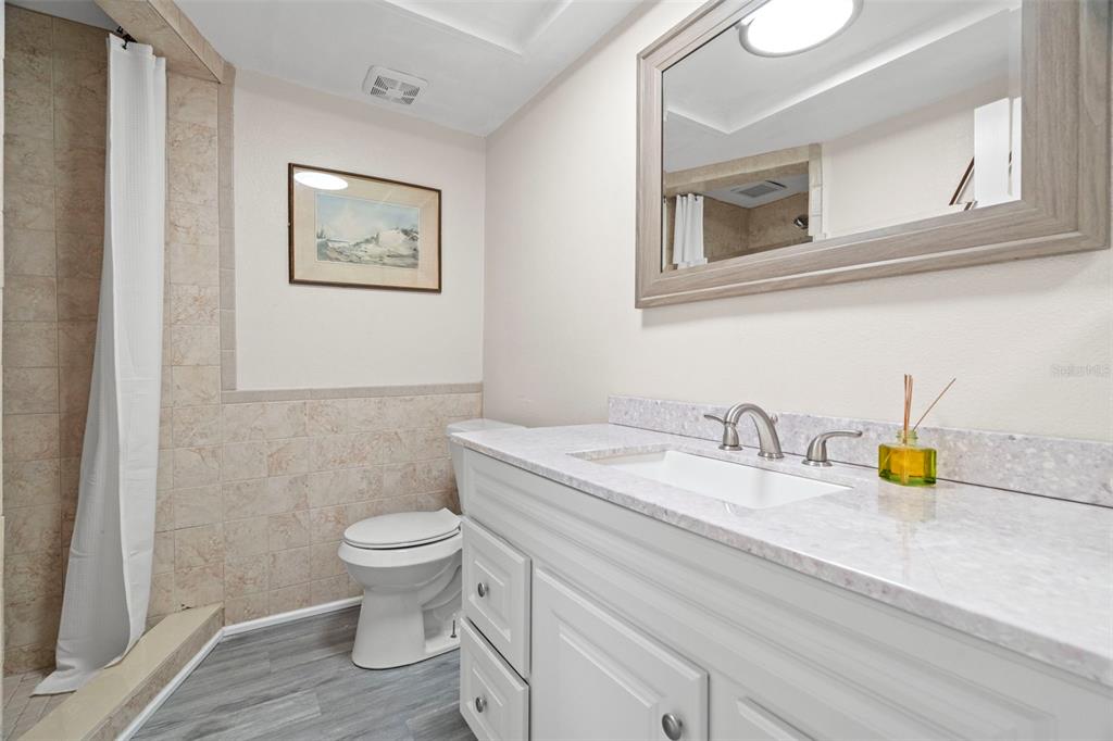 7514 Rocky Point Drive Hudson, FL 34667 - Photo 23 of 38 a bathroom with a granite countertop toilet sink and mirror