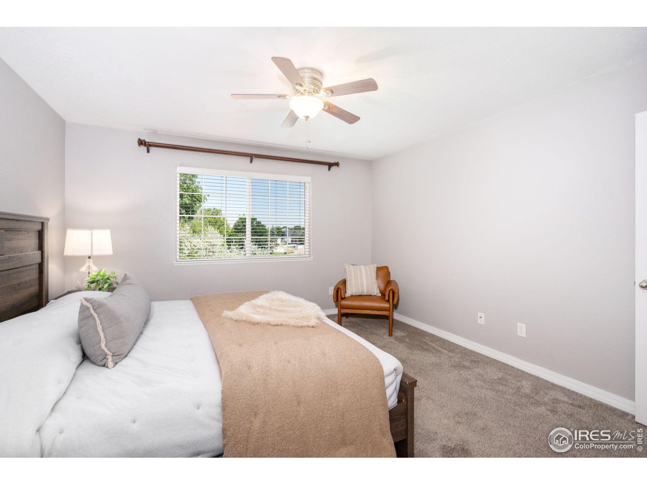 1900 68th Avenue, Unit 4 Greeley, CO 80634 - Photo 16 of 40 a bedroom with a bed and a large window