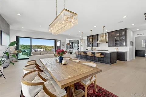 a view of a dining room with furniture a kitchen and chandelier