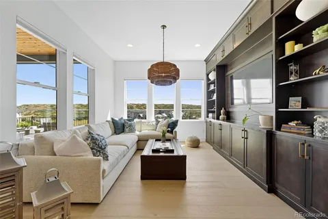 a living room with furniture a chandelier and a large window