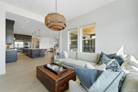 a living room with furniture kitchen view and a large window