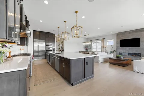 a large kitchen with stainless steel appliances lots of counter space and a wooden floor