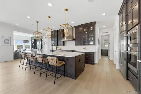 a large kitchen with stainless steel appliances kitchen island granite countertop a large kitchen island a stove a refrigerator a sink a dining table and chairs