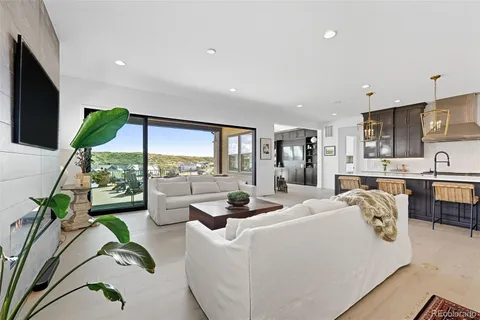 a living room with kitchen island furniture and a flat screen tv