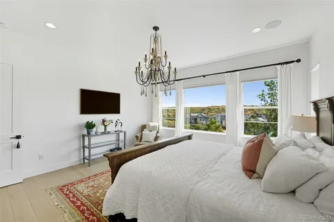 a bedroom with bed tv and a window