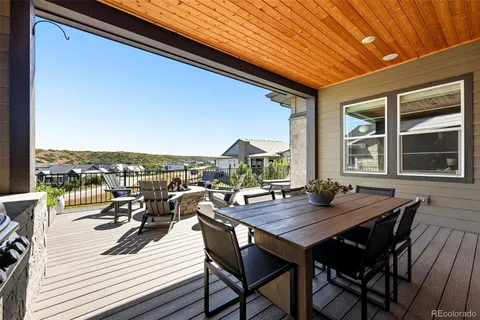 a view of a roof deck with dining table and chairs with wooden floor