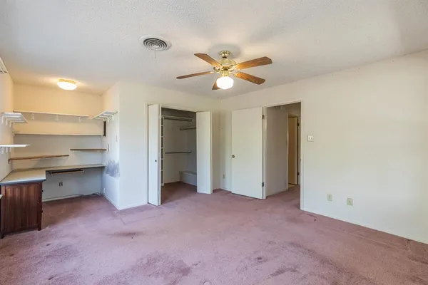 a view of an empty room and a kitchen