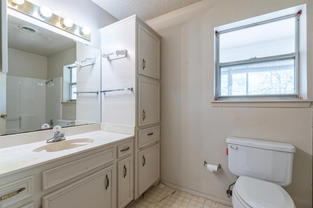 749 Cedar Street Buffalo Gap, TX 79508 - Photo 17 of 30 a bathroom with a toilet a sink and mirror