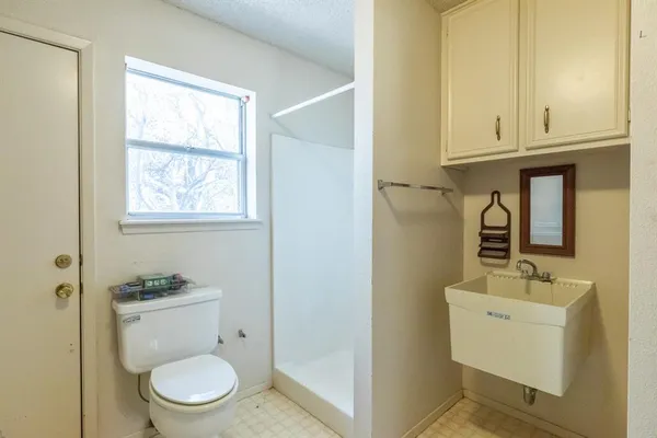 a bathroom with a toilet a sink and mirror