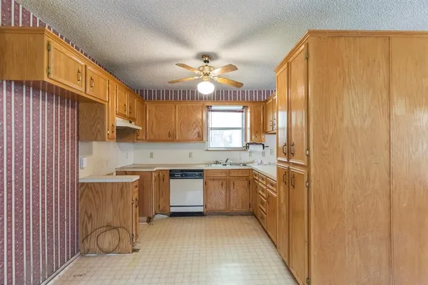 a kitchen with stainless steel appliances granite countertop a sink a stove cabinets and wooden floor