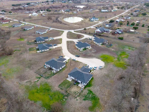 an aerial view of a house with a yard and lake view